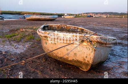 Bateaux à marée basse, amarrés au quai de Morston près de Holt sur la côte nord de Norfolk, East Anglia UK. Photographié au coucher du soleil. Banque D'Images