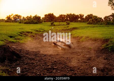 Un âne de poulain très mignon est assis dans un lit de ruisseau séché dans la Nouvelle forêt avec le rouleau occasionnel dans la boue sèche et poussiéreuse. (ensemble d'images) Banque D'Images