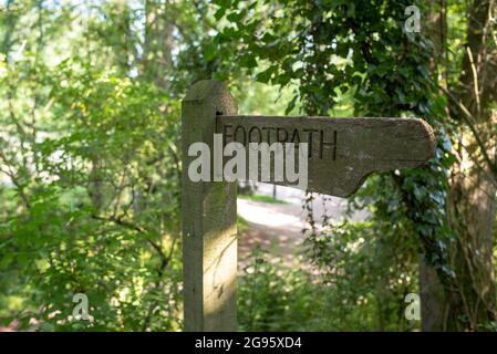 Un panneau de chemin de pied en bois dans les arbres surcultivés marquant une promenade dans le Hampshire Romsey Angleterre. Banque D'Images