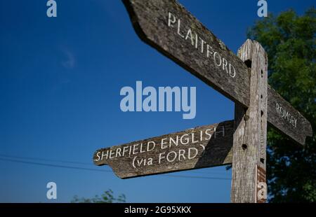Un panneau de signalisation routière en bois de campagne indiquant les directions sur une jonction vers Sherfield English, Plaitford et Romsey dans le comté de Hampshire au Royaume-Uni. Banque D'Images
