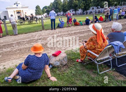 Redefin, Allemagne. 24 juillet 2021. Après un concert, les spectateurs assistent à un spectacle équestre devant la salle d'équitation au niveau du goujon de l'État. Après une pause forcée due à corona l'année dernière, les concerts du festival auront lieu à nouveau dans des conditions de protection de corona. Au total, quatre concerts seront donnés dans la salle d'équitation de la ferme classique de Stud ce week-end. Un maximum de 1250 auditeurs sont admis. Avant le concert, il y avait le traditionnel pique-nique en plein air et un spectacle de chevaux à regarder. Credit: Jens Büttner/dpa-Zentralbild/dpa/Alay Live News Banque D'Images