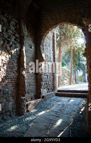 Espagne - Malaga ville, le monument mauresque Alcazaba. Une porte voûtée sur un chemin pavé. Banque D'Images