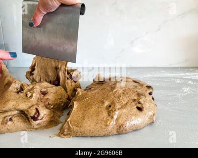 Le boulanger coupe en morceaux de pâte de seigle sur la pâte de levain avant de cuire Banque D'Images