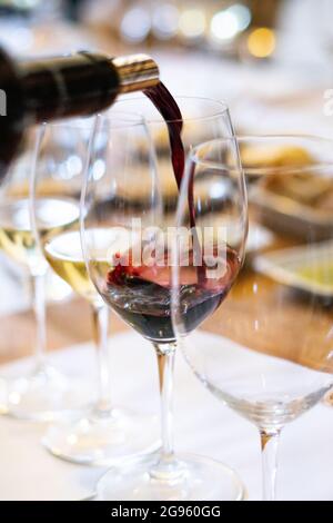 Verser le vin rouge d'une bouteille d'un verre Banque D'Images