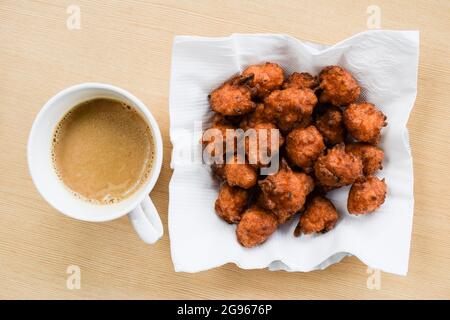 Vue de dessus des beignets de riz appelés pakode de ke chawal à base de riz restant, de besan et de caillé. Plat indien à en-cas spécial avec une tasse de thé. Banque D'Images