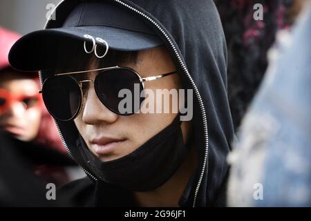 Acteur et chanteur chinois Chen Xuedong (Cheney Chen), portant une casquette de baseball noire avec des détails en anneaux, des lunettes de soleil aviateur sombres et un couvre-visage noir Banque D'Images