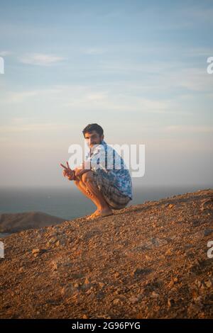 Jeune homme latin avec la barbe souriant à la caméra dans le désert de l'Uribia, la Guajira, Colombie Banque D'Images