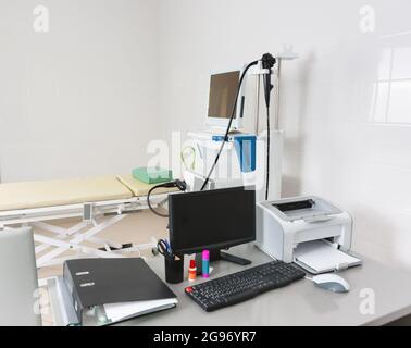 Le bureau des médecins avec un moniteur et un ordinateur dans la salle d'endoscopie. En arrière-plan, il y a un stand avec un oesophagogiodenoscope vidéo Banque D'Images