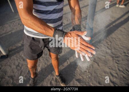 Portrait des mains d'un athlète appliquant la poudre de craie d'haltérophilie pour l'entraînement avec des poids - sportif utilisant l'équipement pendant l'entraînement concept Banque D'Images