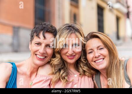 Trois amis matures et joyeux qui regardent ensemble l'appareil photo Banque D'Images