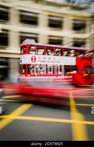 Un tramway passe devant le Pawn, un bâtiment rénové de « Tong lau » ou de centre commercial à WAN Chai, sur l'île de Hong Kong, dans un panoramique avec flou de mouvement sélectif Banque D'Images