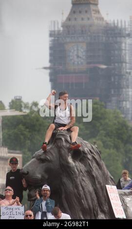 Londres, Royaume-Uni. 24 juillet 2021. Un manifestant réagit positivement à un orateur en lui faisant monter un premier en haut d'une statue de lion pendant la manifestation. Les manifestants protestent à Trafalgar Square, Londres, dans le cadre du rassemblement mondial pour la liberté. Les manifestants manifestent contre le passeport vaccinal, la vaccination Covid-19 pour les enfants et une série d'autres restrictions concernant le coronavirus. (Photo de Martin Pope/SOPA Images/Sipa USA) crédit: SIPA USA/Alay Live News Banque D'Images