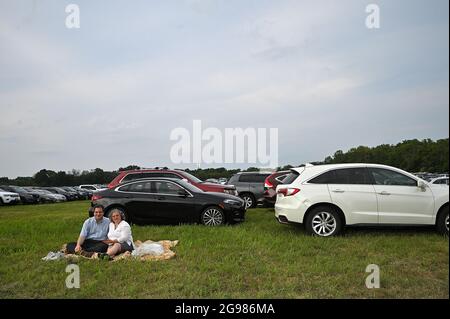 Lecture, États-Unis. 24 juillet 2021. Un couple s'assoit sur une couverture située sur l'herbe d'un parking de fortune, évitant la foule due aux craintes au sujet de COVID-19 mais espérant avoir un aperçu des ballons d'air chaud qui se sont relevés lors du 38e Festival annuel de montgolfières du New Jersey à l'aéroport de Solberg à Reading, NJ, juillet 24, 2021. Les ballons n'ont pas pu voler ou rester gonflés pendant très longtemps en raison de vents forts. (Photo par Anthony Behar/Sipa USA) crédit: SIPA USA/Alay Live News Banque D'Images