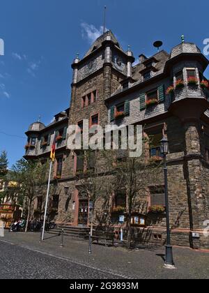 Vue sur l'hôtel de ville historique d'Oberwesel au centre avec façade en pierre ancienne, fleurs et drapeau le jour ensoleillé en été avec ciel bleu. Banque D'Images