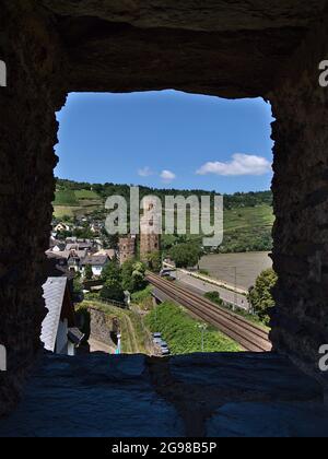 Belle vue sur le mur historique de la ville et tour de guet à travers une fenêtre en pierre dans le village Oberwesel, situé sur la rive du Rhin, avec des voies ferrées. Banque D'Images