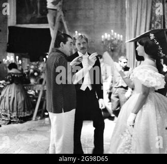 Le réalisateur LUCHINO VISCONTI BURT LANCASTER et CLAUDIA CARDINALE sur scène franche pendant le tournage de la séquence ball dans LE LÉOPARD / il GATTOPARDO 1963 réalisateur LUCHINO VISCONTI roman Giuseppe Tomasi di Lampedusa cinématographie Giuseppe Rotunno costume de Piero Tosi musique Nino Rota Italie - France co-production Titanus / Société Nouvelle Pathe Cinema / Société générale de cinématographie (S.G.C.) Banque D'Images