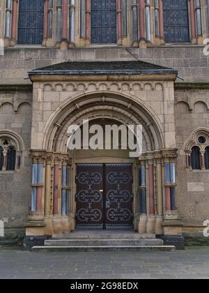 Vue de face symétrique de l'entrée ornementée de l'église historique Herz-Jesu-Kirche construite dans le style néo-roman en 1903 avec des colonnes et des fenêtres en pierre. Banque D'Images