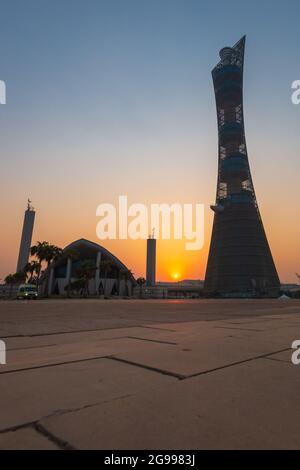 Doha, Qatar – 1er octobre 2019 : la Tour de la flamme dans le complexe de la ville sportive de Doha au coucher du soleil à côté de la mosquée Aspire Masjid contre un ciel clair Banque D'Images