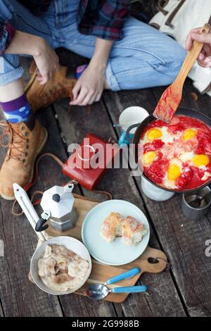 fille préparant le petit déjeuner sur la jetée. camping esthétique dans la nature Banque D'Images