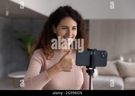 Une femme hispanique souriante tire vlog sur un appareil photo de téléphone portable Banque D'Images