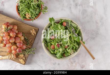 Salade délicieuse à base de raisins grillés caramélisés, d'arugula poivrée, de noix grillées et de pecorino. Excellent repas végétarien. Banque D'Images