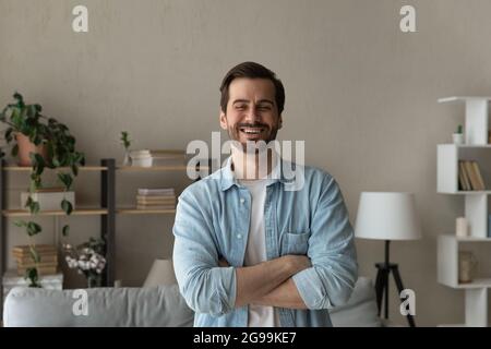 Optimiste Caucasien 30s homme debout à l'intérieur avec les bras croisés Banque D'Images