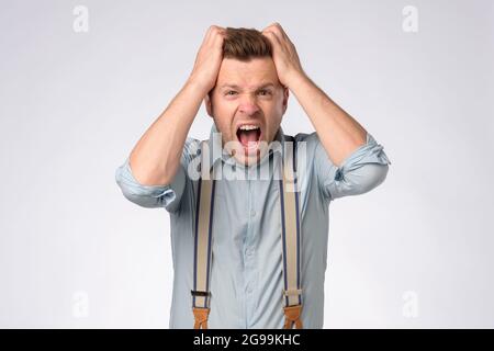 Choqué homme caucasien criant dehors ses cheveux. Banque D'Images