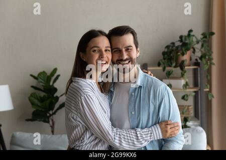 Joyeux rire couple marié embrassant posant à l'intérieur de la maison moderne Banque D'Images