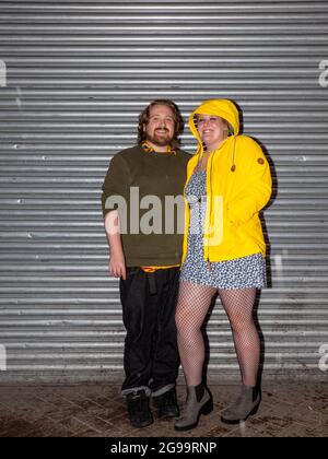 Un couple à l'abri de la pluie un vendredi soir à Sheffield. Banque D'Images