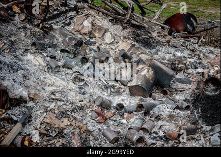 Brûlage de déchets sur un feu de camp contenant des boîtes de conserve métalliques Banque D'Images