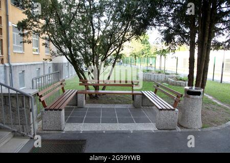 Une place assise à côté de l'entrée de l'école avec trois bancs Banque D'Images