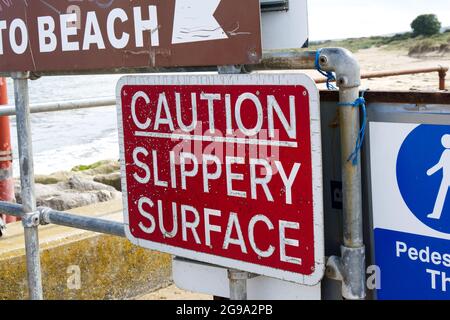 Attention panneau de surface glissante Sandbanks à la chaîne de Shell Beach ferry Poole Dorset Royaume-Uni Banque D'Images