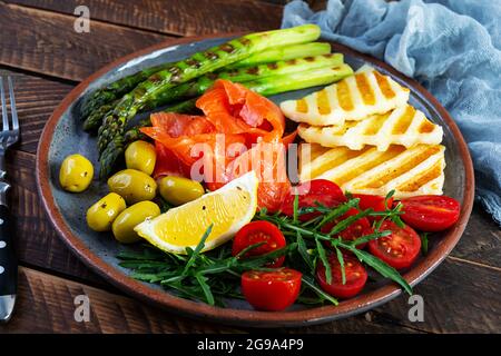 Salade aux asperges, fromage halloumi grillé, filet de saumon, tomates, arugula et olives vertes Banque D'Images