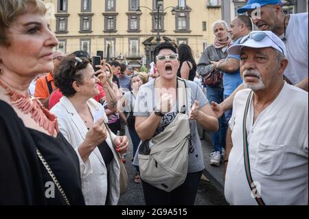 Naples, Italie. 24 juillet 2021. Une femme scanne des slogans pendant la démonstration. Une manifestation nationale contre le Green Pass (carte de santé) qui sera obligatoire pour les repas en intérieur, les manifestations culturelles et sportives, a été organisée dans près de 80 villes en Italie. À Naples, la foule s'est rassemblée sur la Piazza Dante et a essayé d'atteindre la Piazza Plebiscito. Crédit : SOPA Images Limited/Alamy Live News Banque D'Images