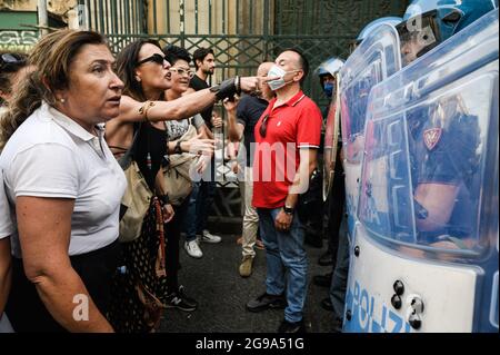 Naples, Italie. 24 juillet 2021. Les manifestants font face aux policiers pendant la manifestation. Une manifestation nationale contre le Green Pass (carte de santé) qui sera obligatoire pour les repas en intérieur, les manifestations culturelles et sportives, a été organisée dans près de 80 villes en Italie. À Naples, la foule s'est rassemblée sur la Piazza Dante et a essayé d'atteindre la Piazza Plebiscito. Crédit : SOPA Images Limited/Alamy Live News Banque D'Images