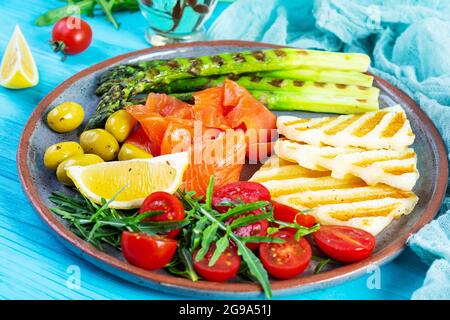 Salade aux asperges, fromage halloumi grillé, filet de saumon, tomates, arugula et olives vertes Banque D'Images