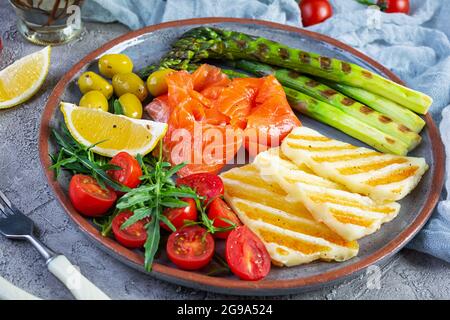 Salade aux asperges, fromage halloumi grillé, filet de saumon, tomates, arugula et olives vertes Banque D'Images