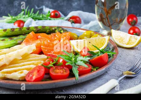 Salade aux asperges, fromage halloumi grillé, filet de saumon, tomates, arugula et olives vertes Banque D'Images