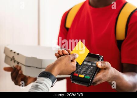 Client méconnaissable payant un courrier mettant une carte de crédit à l'intérieur du terminal Banque D'Images