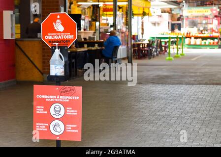 Panneau expliquant les règles sanitaires à respecter et l'assainisseur pour les mains à l'entrée du marché Jean talon, Montréal/pendant la pandémie Covid-19 en cours (Québec, Canada) Banque D'Images