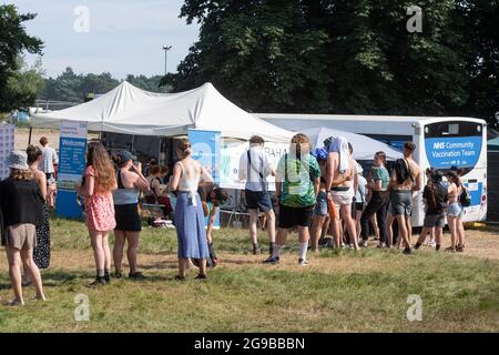 Southwold, Royaume-Uni. 25 juillet 2021. Les festivaliers font la queue pour le coronavirus Vaccines, dans un bus de l'équipe de vaccination de la communauté du NHS, le troisième jour du festival Latitude à Henham Park, Southwold, Suffolk. Le service sans rendez-vous est une coentreprise entre Norfolk et Waverley GCC et les pharmacies GM graham. Date de la photo: Dimanche 25 juillet 2021. Le crédit photo devrait se lire: Matt Crossick/Empics/Alamy Live News Banque D'Images