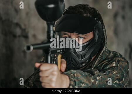 Portrait du joueur de paintball, jeu dans lequel les participants simulent des combats militaires en utilisant des pistolets à air pour tirer des capsules de peinture les uns aux autres, le sport Banque D'Images