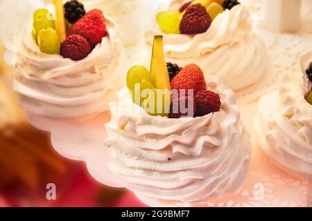 Pâtisseries, préparation et vente de délicieux gâteaux. Pavlova, dessert à la meringue australienne et néo-zélandaise, crème, meringue et fruits frais. Délicieux Banque D'Images