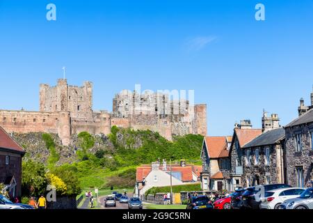 Le légendaire château de Bamburgh, un bâtiment classé de catégorie I sur la côte nord-est de l'Angleterre, vu du village de Bamburgh dans Northumberland sur une d ensoleillée Banque D'Images