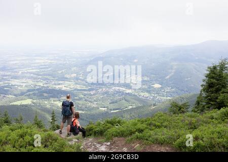 Couple de deux touristes, routards, randonneurs et randonneurs ont un repos et regardant de l'observation et de la perspective. Smrk, montagnes de Beskid, République tchèque Banque D'Images