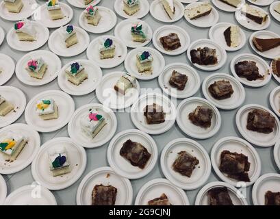 Soupir de bazar couvert de l'église.Assortiment de tranches de gâteau sur des assiettes en papier. Banque D'Images