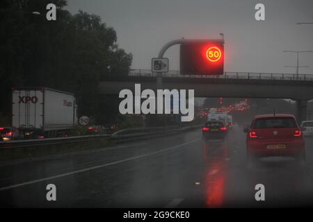 Des restrictions de vitesse sont en place sur l'autoroute, car les voitures et la circulation circulent dans des conditions météorologiques extrêmement humides Banque D'Images