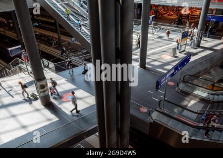 Vue intérieure de la gare ferroviaire avec escalier roulant, passagers et train régional de la société Deutsche Bahn à la gare centrale de Berlin. Banque D'Images