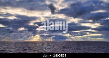 Rayons du soleil traversant des nuages sombres. Le drame imprévisible du ciel. Vue depuis un bateau de croisière touristique naviguant dans l'océan Pacifique Nord. 2 juin Banque D'Images