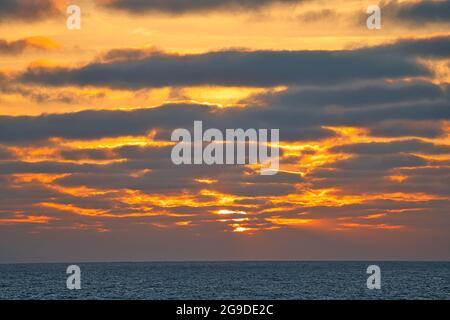 Rayons du soleil traversant des nuages sombres. Le drame imprévisible du ciel au coucher du soleil. Vue depuis un bateau de croisière touristique naviguant dans l'Oce du Pacifique Nord Banque D'Images